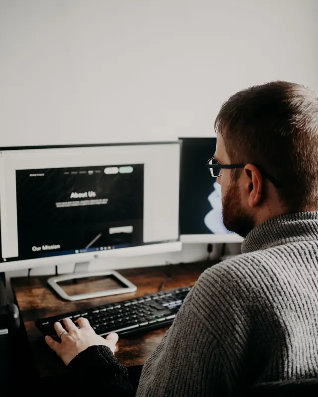Pessoa acompanhando números em dois monitores